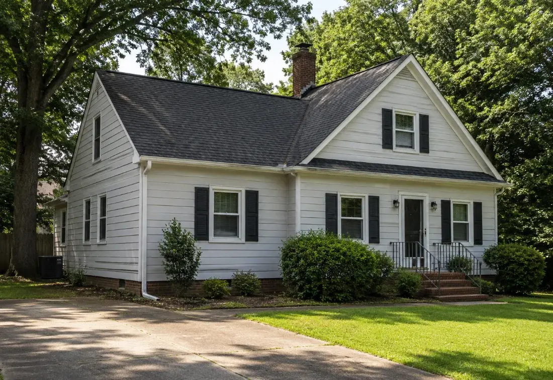 White cape cod style home with a finished roof