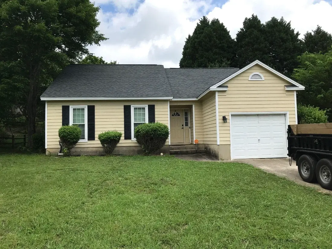 Yellow ranch home with a new shingle roof