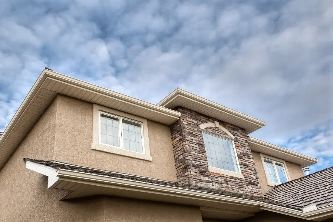 Close-up of a stucco home roofline and gutter detail