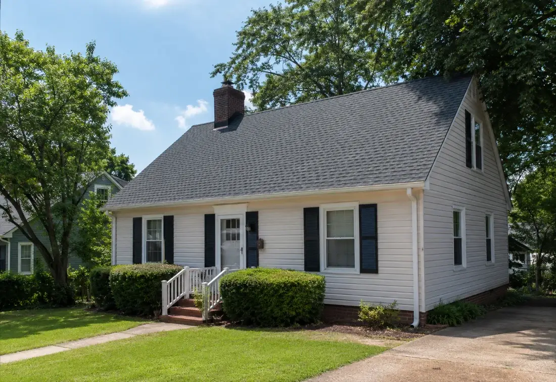 White cape cod home with a new shingle roof